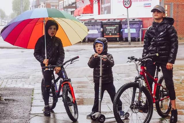 Photographer Sophia Benham from North End has been capturing images of families during lockdown as part of her #atourfrontdoor project to raise money for domestic abuse charity Aurora New Dawn. Pictured: Sophia's sons Kit, Rex and Beau helping her take pictures on a rainy day