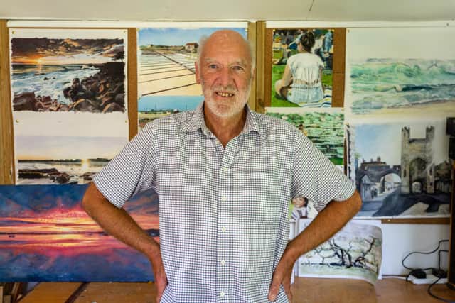 Ian Andrews in front of his paintings. Photo by Mathew Clark