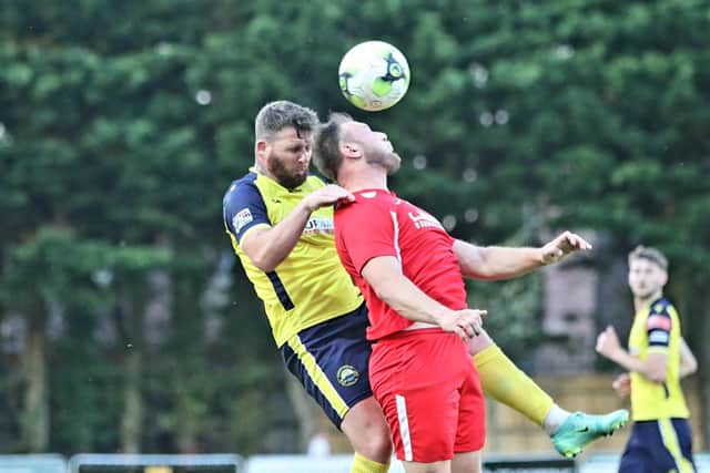 Gosport defender Ryan Woodford (yellow) goes up for a header with Horndean's Connor Duffin. Picture: Tom Phillips