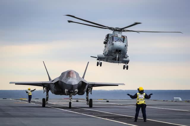 Pictured: A Merlin Mk4 From 845 Naval Air Squadron takes off as an F-35 prepares to launch from HMS Queen Elizabeth's flight deck.