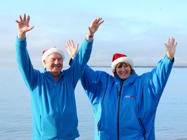 Dave and Sue Castle, from Lee-on-the-Solent, enjoy the warm layers after taking a dip. Picture: Sarah Standing (261224-459)