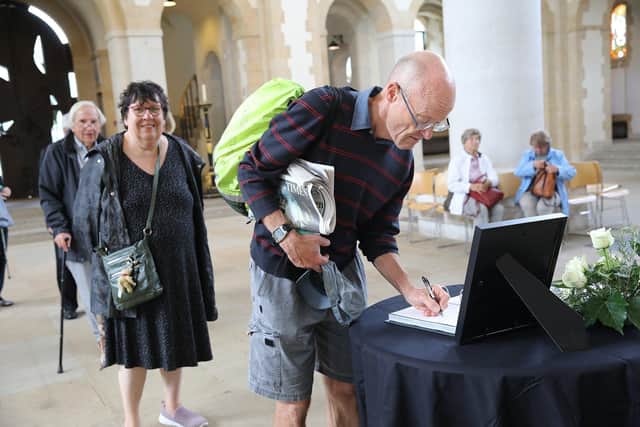Richard Derrick signs the book of condolence in Portsmouth Cathedral