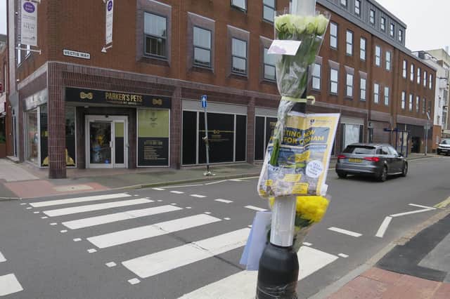 Flowers and a police sign appealing for witnesses have been put in Cosham high street near Vectis Way, where an 85-year-old woman died in a van crash on October 7 2021. Picture: Ben Fishwick