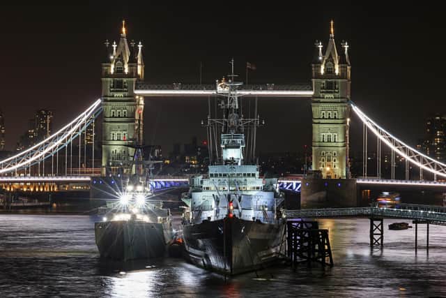 HMS Severn outboard HMS Belfast on the River Thames near Tower Bridge at night 27th August 2021.