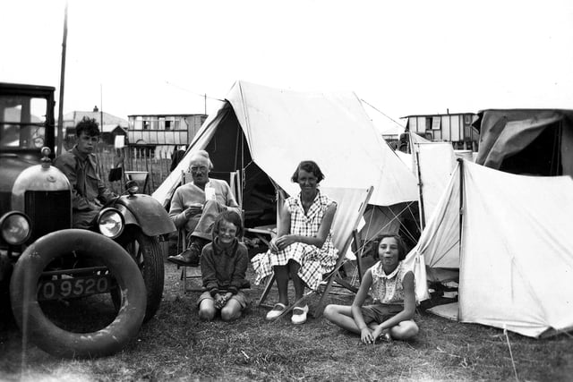 Camping at Hayling Island is 1932. Behind the tent is a selection of old railway carriages that have been converted into holiday accommodation