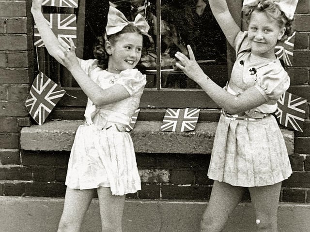 Festival of Britain street tea outside 14, Moorland Road, Buckland Portsmouth. Kay Britno, aged 9, (on left) and friend from Madame Selwood's dance troop
outside her grandparent’s house entertaining the neighbours at a Festival of Britain street party in 1951