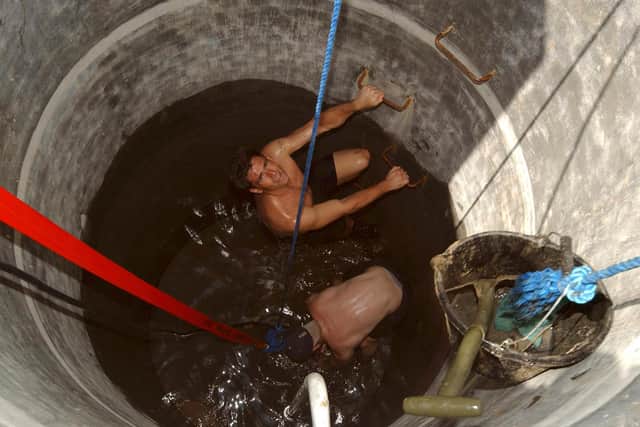 Royal Navy personnel from HMS Chatham assist the local inhabitants of Kallar Village by clearing debris and rubble from the local school and hospital and cleaning out a drinking water well which is contaminated with salt water. Chief Petty Officer Clerk and Petty Officer Slater clean out the well.