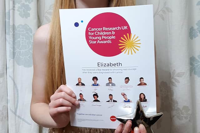 Elizabeth Rooney with her Cancer Research UK Children and Young People Star Award after facing cancer for seven years