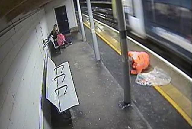 A CCTV image issued by the Rail Accident Investigation Branch dated 19/12/2020 of the moment a rail worker removing rubbish from train tracks at Rowlands Castle statio narrowly avoided being hit by a train. Picture: RAIB/PA Wire