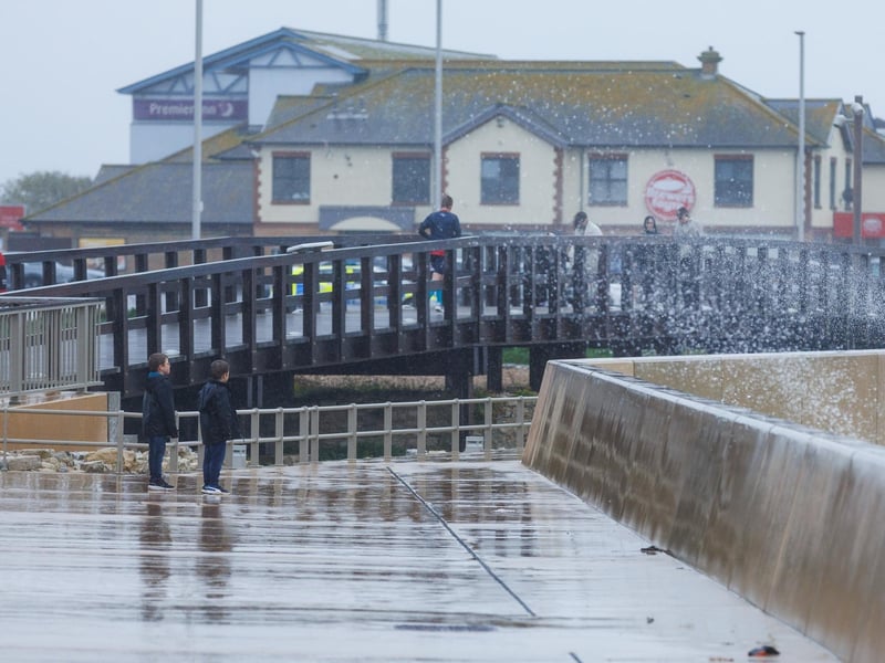 The stormy sea at high tide crashed waves onto footpaths as passer-by's did their best to get out the way