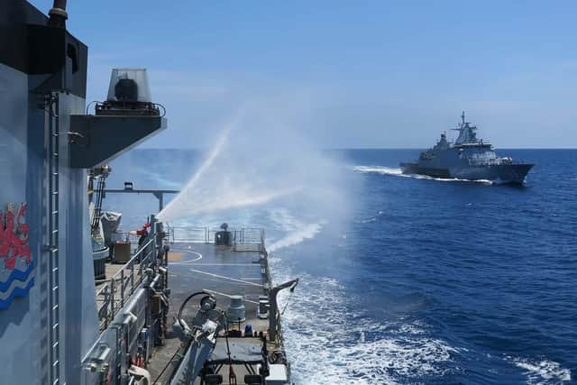 HMS Tamar tests her water canons during the drills in Malaysia