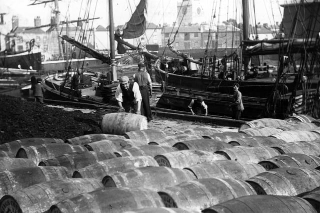 circa 1900:  Barrels being unloaded from a ship in Portsmouth Dock.  (Photo by F J Mortimer/Hulton Archive/Getty Images)