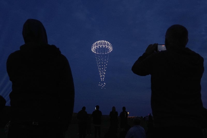 Drones make a parachute during a drone display telling the story of D-Day. Photo: Andrew Matthews/PA Wire