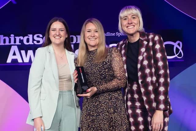 Natalie and Sarah from the HIOWAA Engagement team are presented with the award by host and comedian Maisie Adam