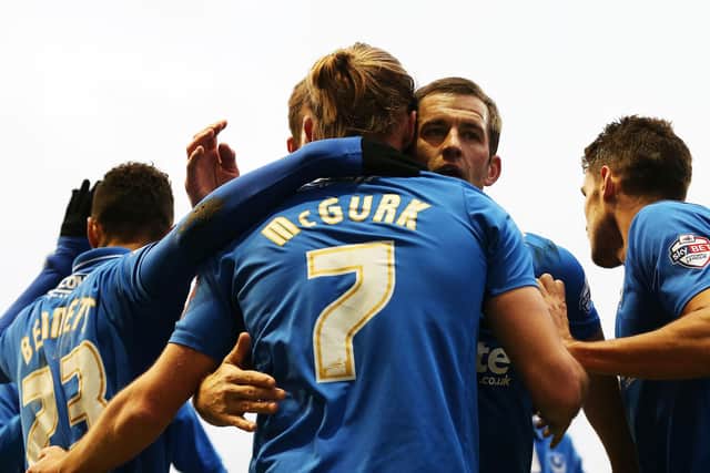 Adam McGurk is embraced by Pompey skipper Michael Doyle and other team-mates after netting in the FA Cup against Accrington Stanley in December 2015. Picture: Joe Pepler