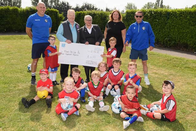 Fleur De Lys receive a £400 cheque from the local Co-op. Back (from left): Jerome Carroll (FDL vice chairman), Dave Brown (Salisbury Road Co-op, Cosham), Sarah Cunningham (Drayton Funeral Care, Co-op), Kerrie Kilford, Steve Jackson (FDL chairman). Also pictured are some of the club's Soccer Tots. Picture: Keith Woodland