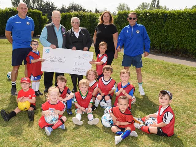 Fleur De Lys receive a £400 cheque from the local Co-op. Back (from left): Jerome Carroll (FDL vice chairman), Dave Brown (Salisbury Road Co-op, Cosham), Sarah Cunningham (Drayton Funeral Care, Co-op), Kerrie Kilford, Steve Jackson (FDL chairman). Also pictured are some of the club's Soccer Tots. Picture: Keith Woodland