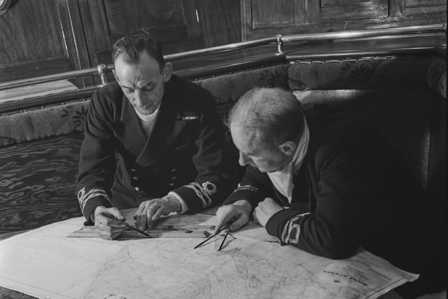 Officers with a map below decks on a Royal Navy minesweeper during World War II, March 1941.  (Photo by Horace Abrahams/Keystone Features/Hulton Archive/Getty Images)