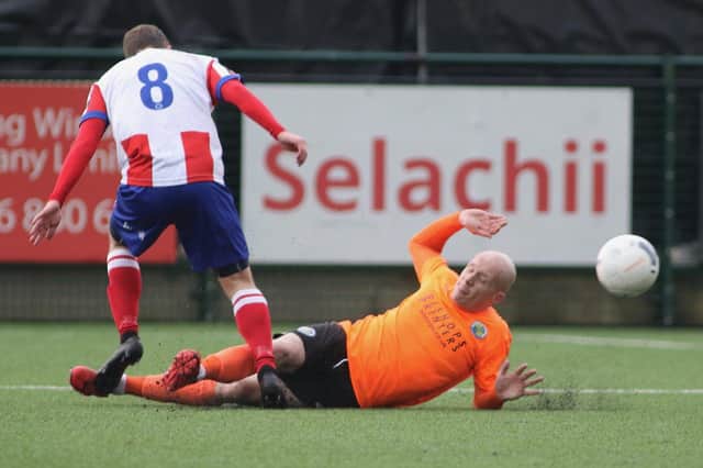 Nicky Bailey, right, makes a sliding tackle during Hawks' weekend win at Dorking. Picture: Kieron Louloudis