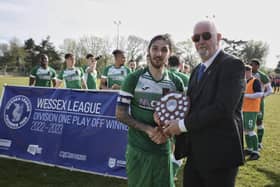 Connor Hoare receives the Wessex League Division 1 play-off trophy after his side's penalty shoot-out win at New Milton. Picture by Robin Caddy.