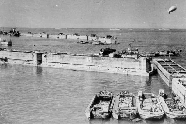 Phoenix caissons, part of the Mulberry Harbour at Arromanches. These were huge concrete structures, built along the south coast, including locally on Hayling Island, Stokes Bay and in the dockyard. They were sunk in rows as seen here, to form a breakwater for the harbour, creating an inner area of calmer water, to help shelter small craft if there was a storm