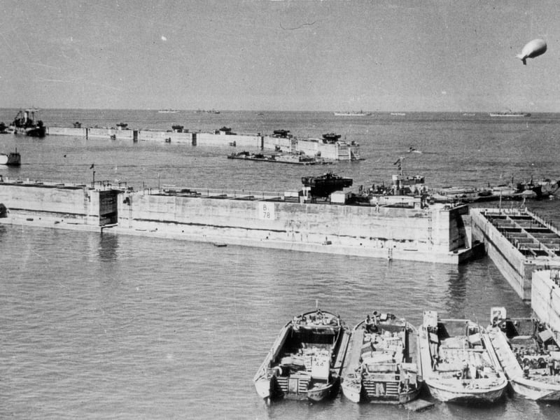 Phoenix caissons, part of the Mulberry Harbour at Arromanches. These were huge concrete structures, built along the south coast, including locally on Hayling Island, Stokes Bay and in the dockyard. They were sunk in rows as seen here, to form a breakwater for the harbour, creating an inner area of calmer water, to help shelter small craft if there was a storm