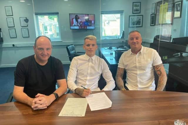 Waterlooville's Liam Wiseman signing his professional deal, centre, with promoter Steve Goodwin, right, and father and main coach Daron Wiseman