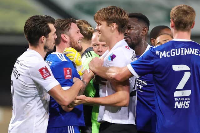 Sean Raggett squares up to Ipswich front man James Norwood during yesterday's FA Cup first-round game at Portman Road. Picture: Nigel Keene.