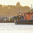 Around 140 migrants arrive in Portsmouth, Hampshire after being transferred from a single dingy south of the Isle of Wight in the English Channel by two RNLI lifeboats, a mammoth operation is talking place on Sunday evening to process the illegal migrants, with dozens of government workers from Police, Border Force, Ambulance and Fire crews, along with a number of transport busses. Viewed from Hayling Island, just across the water.  Dated 06/09/26.
