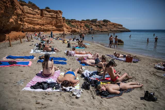 Tourists enjoy Playa es Bol Nou beach in Ibiza. (Photo by Zowy Voeten/Getty Images)