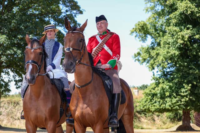 Jo Hyland and Brian Hyland of the Rebellion Reenactment Cavalry (Mounted) ride into Saturday's action at Fort Brockhurst