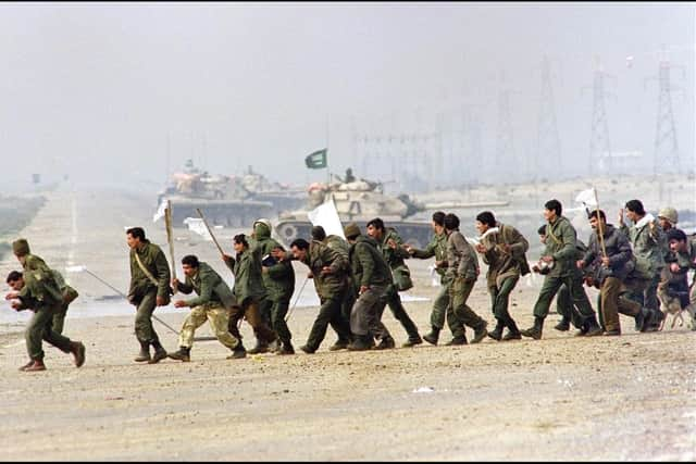 Iraqi soldiers cross a highway carrying white surrender flags on February 25, 1991 in Kuwait City. Picture: CHRISTOPHE SIMON/AFP via Getty Images