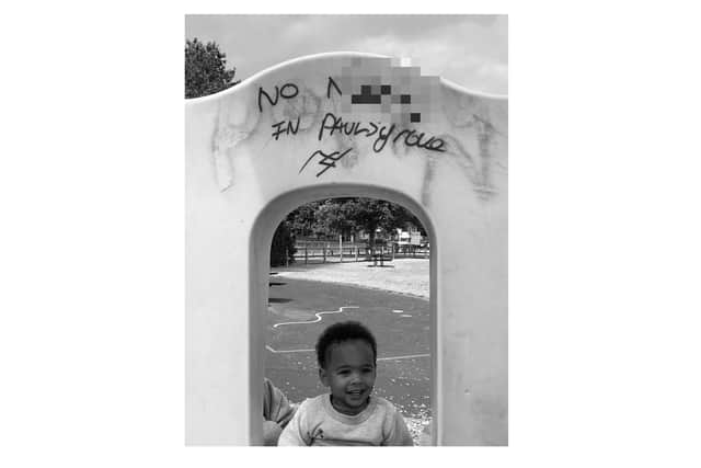 Jodie Patton went to the play park and spotted a disgusting racist message plastered over an arch. Pictured is the slur, with 14-month-old half African baby, Pablo Mota, underneath. Picture: Jodie Patton.