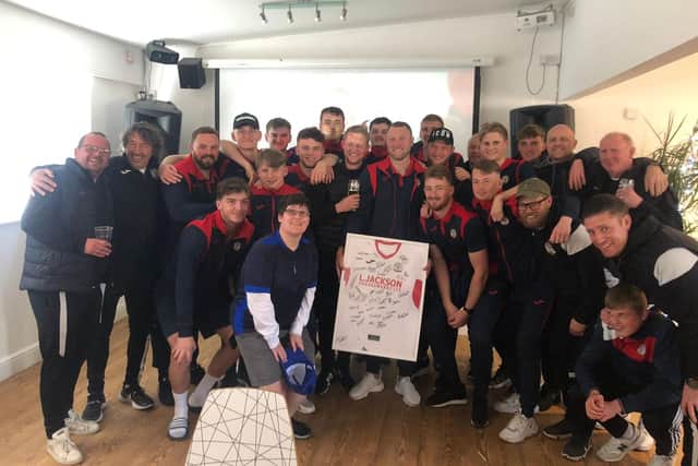 Louie Martin, centre, holds a framed Horndean shirt signed by his team-mates as the management staff and players come together after his final club appearance