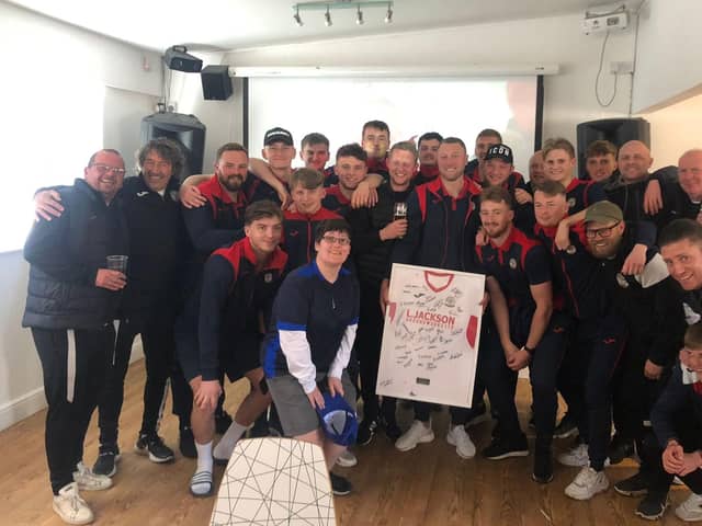Louie Martin, centre, holds a framed Horndean shirt signed by his team-mates as the management staff and players come together after his final club appearance