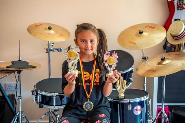 8-year old drummer Mia Mallari with some of the trophies she has won for her drumming. Picture: Mike Cooter (060822)