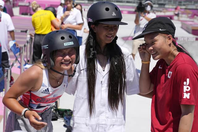 Twelve-year-old silver medalist Kokona Hiraki, of Japan, centre, and gold medalist Sakura Yosozumi of Japan and bronze medalist Sky Brown of Britain, left, celebrate after the women's park skateboarding finals. Picture: AP Photo/Ben Curtis.