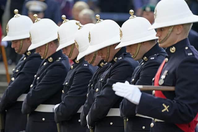 Royal Marines bow their heads as the coffin of Major General Matthew Holmes, the former head of the Royal Marines, is carried into Winchester Cathedral in Hampshire for his funeral. Andrew Matthews/PA Wire