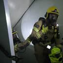 Firefighters working their way through a building while the officer in the centre carries one of the new, fluorescent smoke hoods designed to help evacuate people from blazing buildings. Photo: Hampshire and Isle of Wight Fire and Rescue Service.