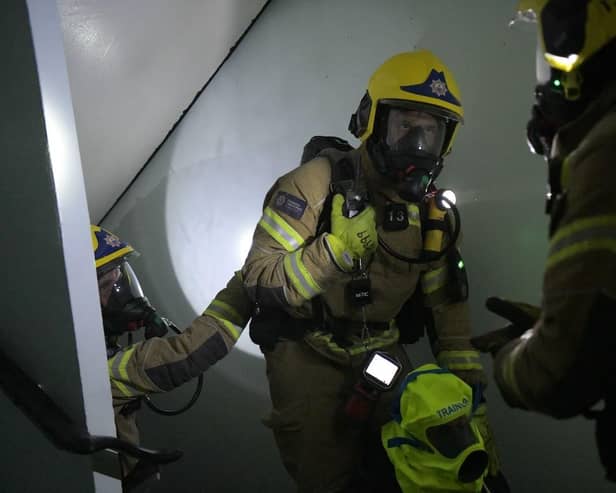 Firefighters working their way through a building while the officer in the centre carries one of the new, fluorescent smoke hoods designed to help evacuate people from blazing buildings. Photo: Hampshire and Isle of Wight Fire and Rescue Service.