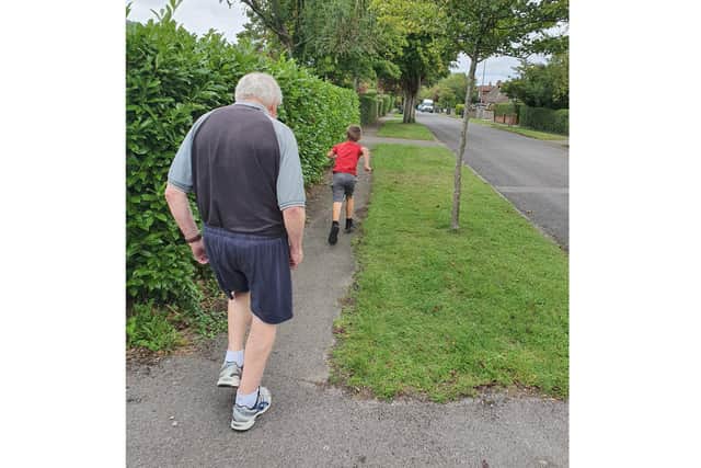 Kobe Brown, 7, is running a mile a day to raise money for Parkinson's UK because his grandad has the neurological condition. Pictured: Grandad John Manning, 73, walking behind Kobe
