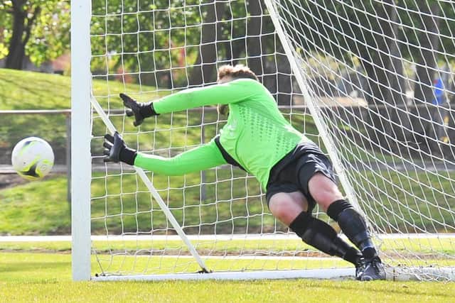 Tom Price dives to stop Danny Finnegan's penalty in the Wessex League Cup semi-final shoot-out. Picture: Martyn White