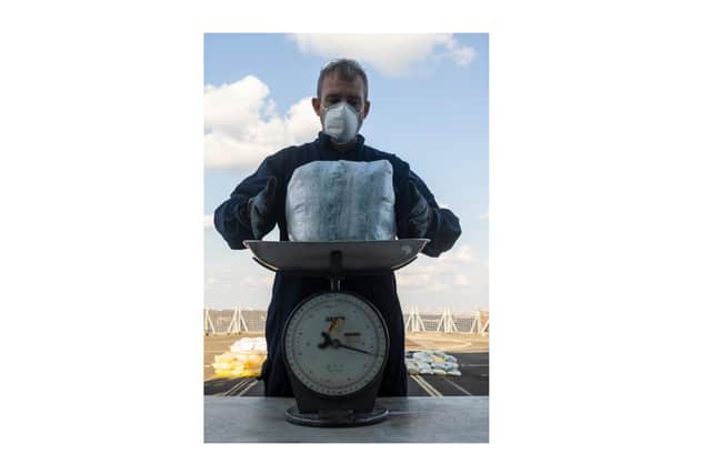 A sailor on HMS Montrose weighs some of the drugs seized by the ship earlier this month