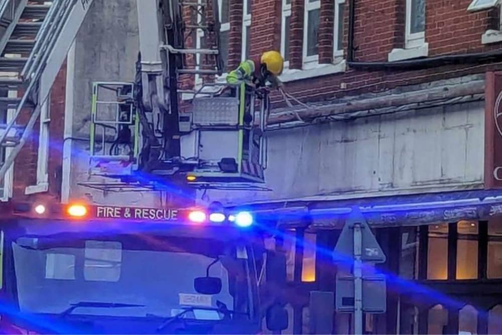 Firefighters fixing loose roof tiles and a sign above Poppins Cafe in North Street, Havant, on January 2.