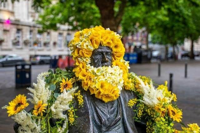 The Charles Dickens statue in Guildhall Square has been covered in flowers.