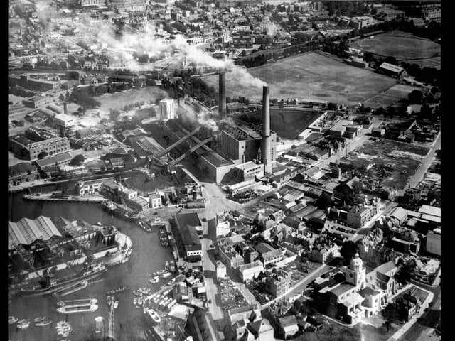 Old Portsmouth Power Station circa 1948.To the bottom left is the Camber with the coal hoppers of Fraser & Whites the coal merchant. Unloading at the wharf is a large collier with three barges alongside.At the pointed end of the coal wharves can just be seen the Bridge Tavern which is dwarfed by them. Above the Bridge Tavern is the lock for the coal barges that brought in coal for the power station.The covered travelators for taking the coal up and over Gunwharf Road can be seen.Above the lock are the buildings of HMS Vernon. To the bottom right can be seen Oyster Street which at this time  passed into White Hart Lane and since these times a block of flats have been built over it.St Thomas Street passes behind the cathedral with many of the buildings just bomb sites. The bank now a residential building on the corner of Highbury Street can be Cleary seen. The east end of St Thomas's Street and Warblington Street leading into St Georges Road close by Landport Gate are both bomb sites. To the top right hand corner can be seen the United Services cricket ground where, up until the Rose Bowl was built, Hampshire played first class cricket.  Above the power station chimneys the railway line from the Harbour station to Portsmouth & Southsea High Level can be seen running along its tree lined route.