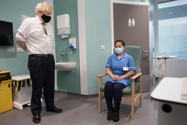 Prime Minister Boris Johnson speaks to Jennifer Dumasi who is being vaccinated Oxford/AstraZeneca Covid-19 vaccine during his visit to Chase Farm Hospital. Picture: Stefan Rousseau/PA Wire
