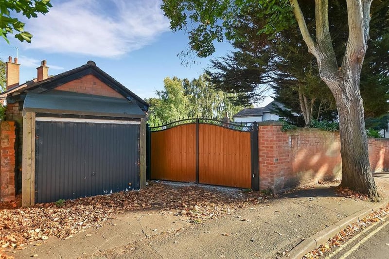 The electric gates off Terrace Road that lead to the parking area at the end of the back garden. Next to the driveway is a brick-built outbuilding.