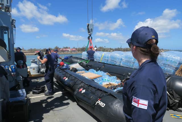 Lieutenant Commander MacNae, looks on as craning operations take place to unload bottled water. As the Second in Command on HMS Spey she oversees and coordinates the relief operations.