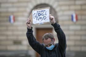 Demonstrators take part in the Take A Knee for George Floyd solidarity protest organised by Stand Up To Racism Scotland, outside St Giles' Cathedral  in Edinburgh in memory of George Floyd